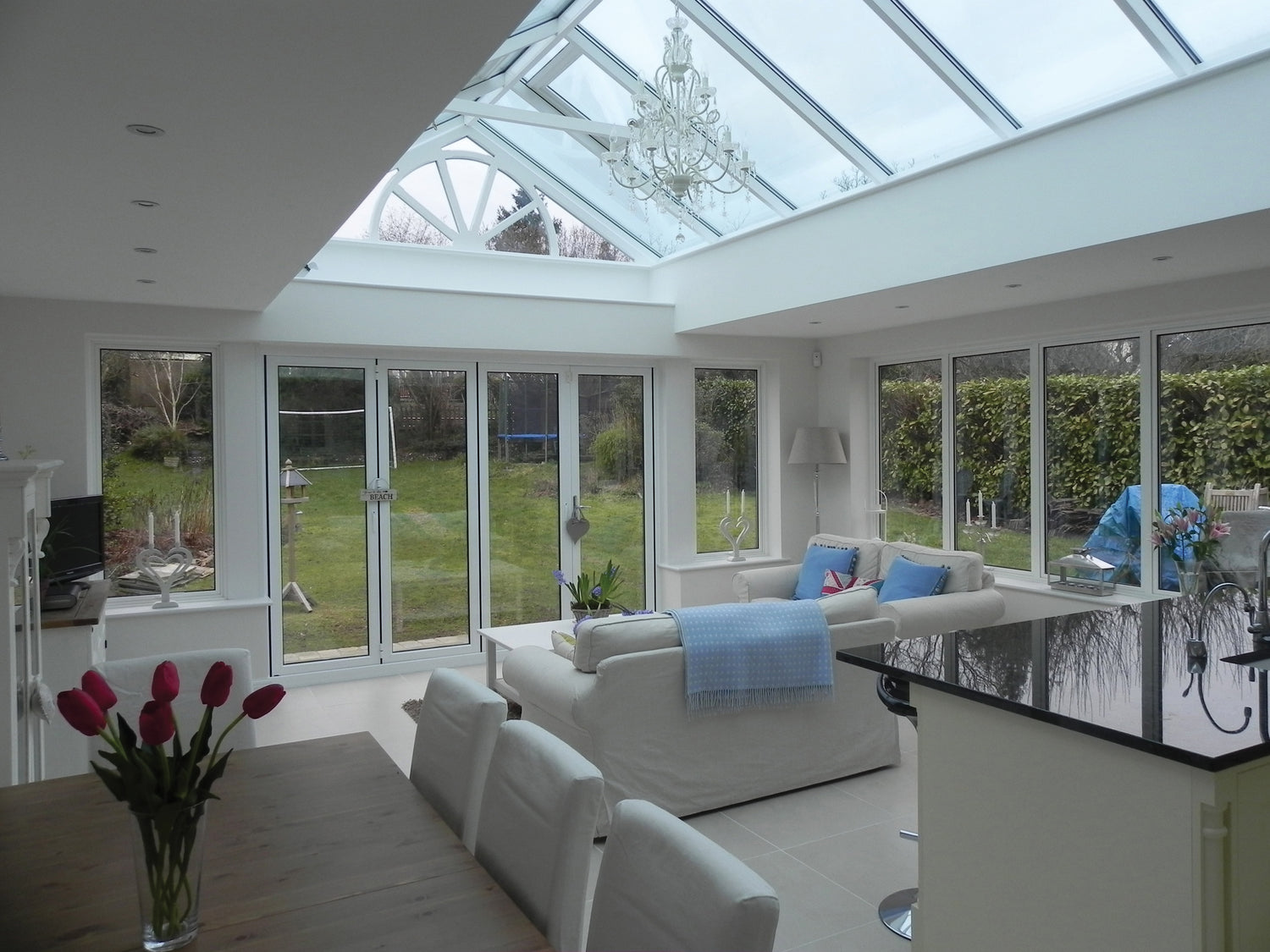 Modern living room with large glass roof and white furniture